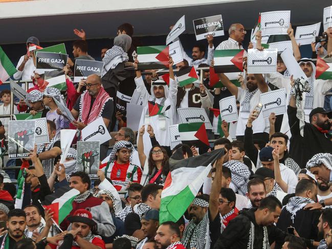 Supporters wave Palestinian flags prior to the 2026 FIFA World Cup AFC qualifiers football match between Palestine and Australia. (Photo by Yasser Al-Zayyat / AFP)