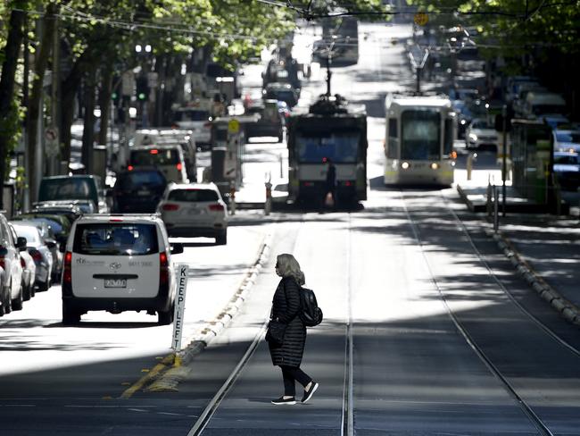 MELBOURNE, AUSTRALIA - NewsWire Photos OCTOBER 20, 2021: A person crosses Collins Street as Melbourne continues with its current Covid lockdown. Picture: NCA NewsWire / Andrew Henshaw