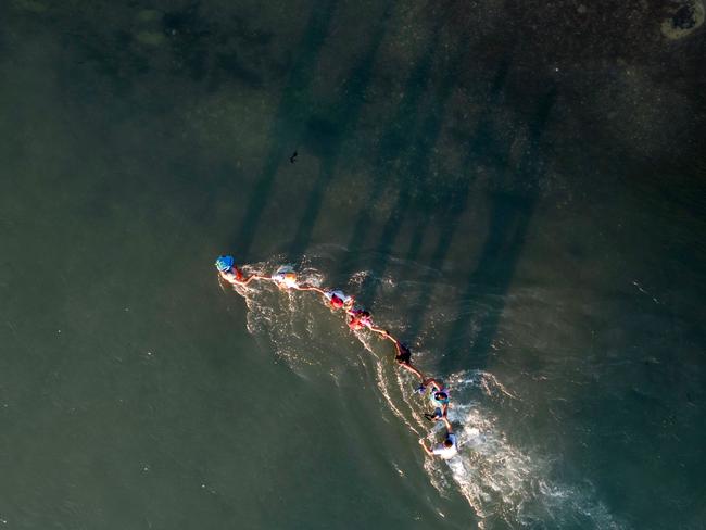 This aerial picture shows a family holding on as they try to navigate swift currents in the Rio Grand river as they cross the US-Mexico border to Eagle Pass, Texas. Picture: Andrew Caballero-Reynolds/AFP