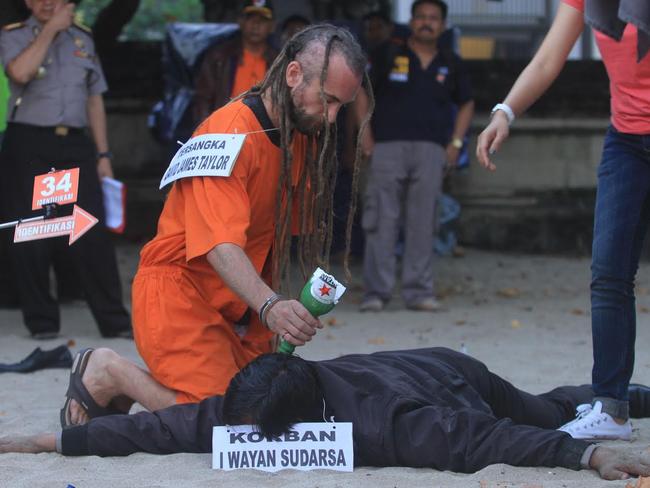 David Taylor appears to strike an officer with a bottle during the re-enactment on Kuta Beach. Picture: Zul Edoardo.