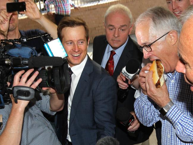 Prime Minister Malcolm Turnbull gets stuck into a democracy sausage during campaigning at Gladesville Public School. Picture: AAP