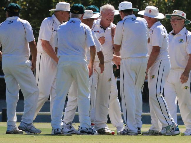 Ron Kasputtis (middle) is congratulated after taking a wicket for the Australian Over 70s cricket side against England in 2018. Picture: Peter Ristevski