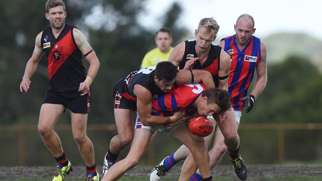 Frankston Bomber Sam Fox tackles Rye player Harry Whitty, who is determined to keep his nose over the ball. Picture: Chris Eastman.