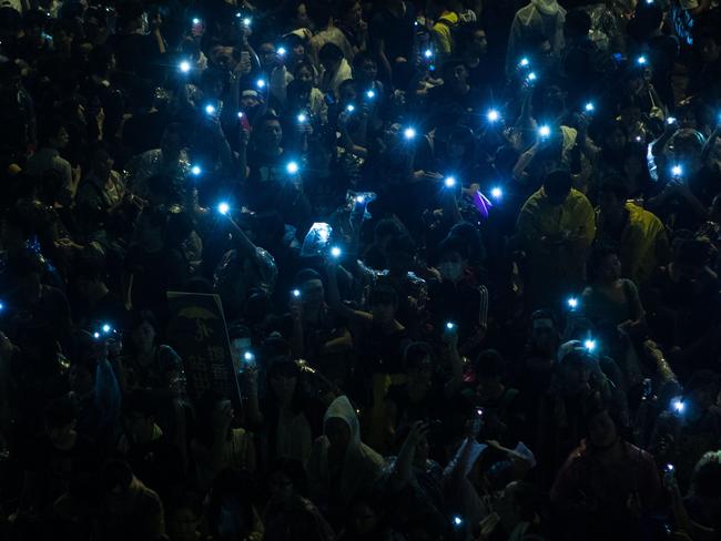 Pro-democracy protesters hold up their mobile phones after heavy rain in Hong Kong on September 30, 2014.