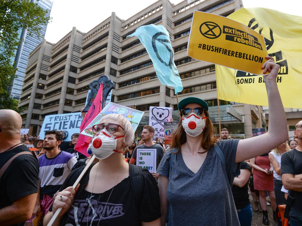 Protesters hold placards during a 'Sack ScoMo!' climate change rally in Sydney, Friday, January 10, 2020. (AAP Image/Paul Braven)