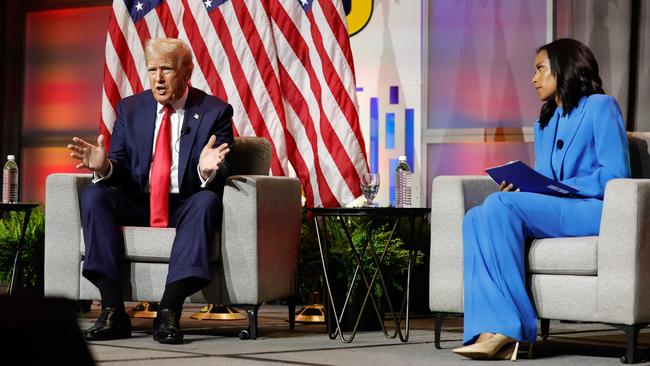 Former US President and 2024 Republican presidential nominee Donald Trump answers questions as moderator and journalist Rachel Scott (R) looks on during the National Association of Black Journalists annual convention in Chicago, Illinois.