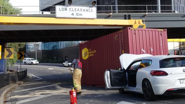 Fire crews cleaning up after the shipping container smashed into the car. Picture: Martin Wurt