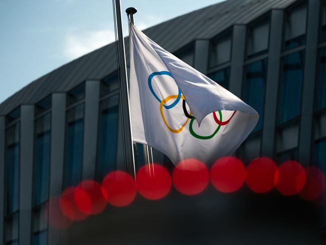 (FILES) This file photo taken on March 8, 2021 shows the Olympic flag floating next to the headquarters of the International Olympic Committee (IOC) in Lausanne. - Ukrainian Presidential aide Mykhaylo Podolyak on January 30, 2023 called the International Olympic Committee (IOC) a "promoter of war" after the sports body said it was considering ways for Russian athletes to compete. (Photo by Fabrice COFFRINI / AFP)