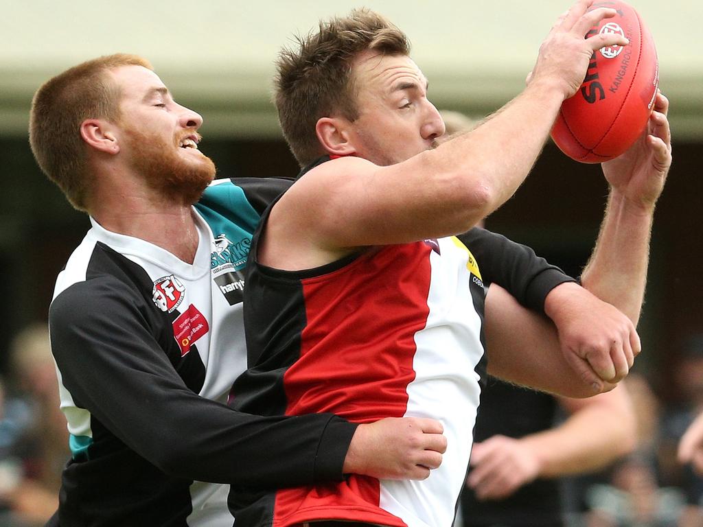 Essendon District: Lynden Dunn of West Coburg marks strongly under pressure from Hillside’s Ryan Deppeler. Picture: Hamish Blair