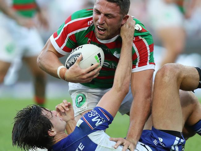 Souths Sam Burgess is tackled by Bulldogs Lachlan Lewis during the South Sydney v Bulldogs NRL match at ANZ Stadium, Homebush. Picture: Brett Costello