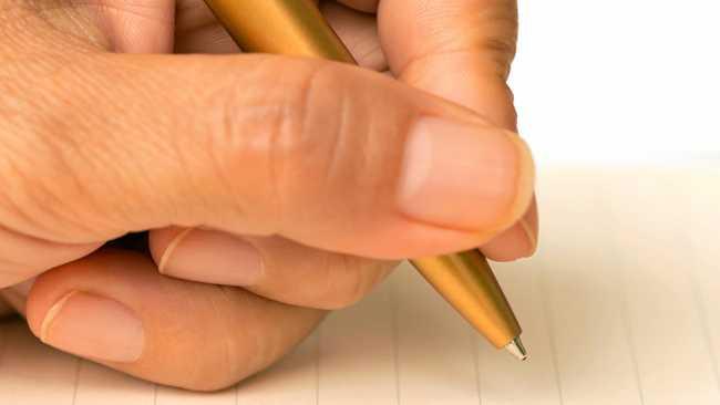 Women writing on paper with a pen on a white background. Picture: wisawa222