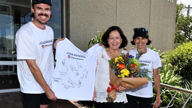 Pace Shavers Nathan Edwards and Kerry Schreiber present Ballina mayor Sharon Cadwallader with a bouquet of flowers and a signed T-shirt as they reached Ballina after trekking more than 200km from Brisbane.