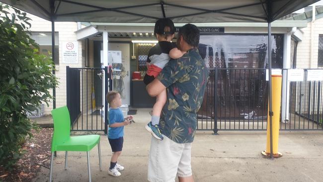 Darren Budini waits for a COVID test with his two toddlers