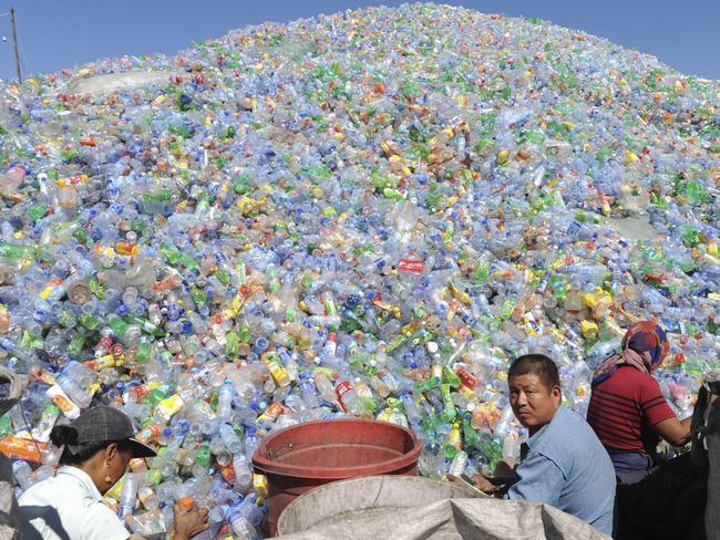 Workers sort recyclable plastic bottles at a bottle recycling site in Shenyang, in northeast China's Liaoning province, Aug. 20, 2009. (AP Photo) ** CHINA OUT **