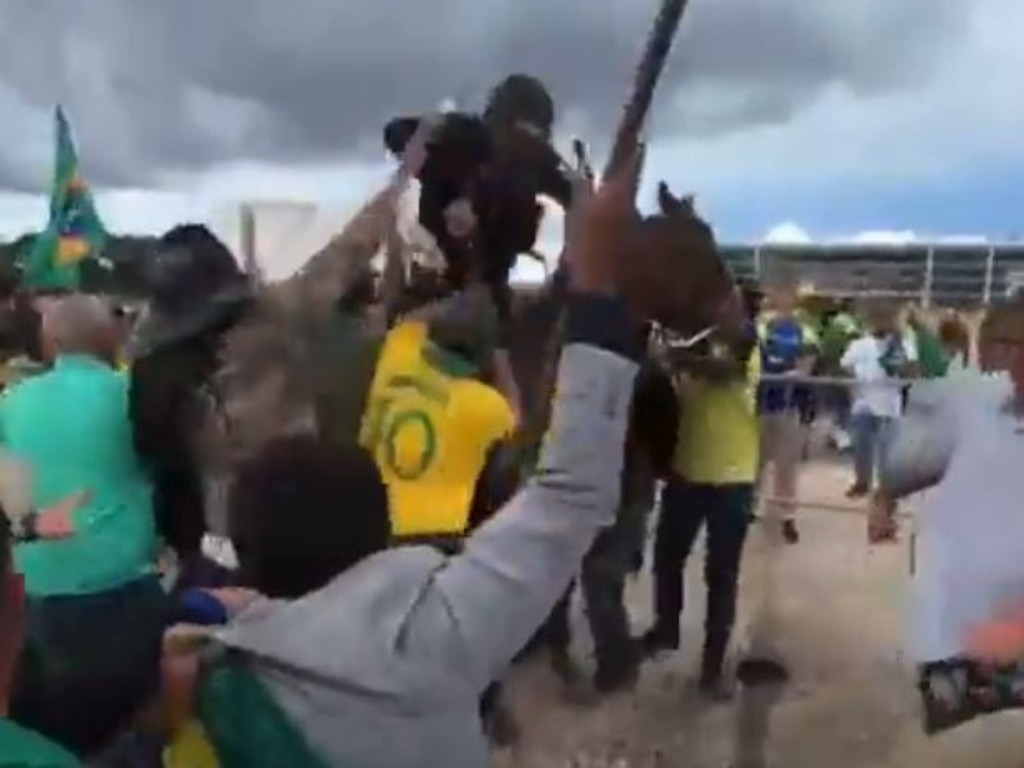 Bolsonaro supporters beat a police officer and the horse he is riding. Picture: Twitter