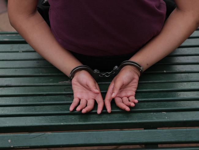 A gang member is arrested in Mt Druitt and taken away by police.