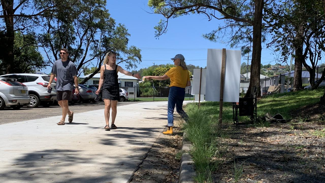 Voters are handed a flyer at Lismore High during the 2021 Lismore City Council local government election.