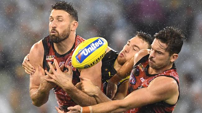 Cale Hooker leads opponent Noah Balta to the ball during a sodden first half at the MCG. Picture: Quinn Rooney/Getty Images.