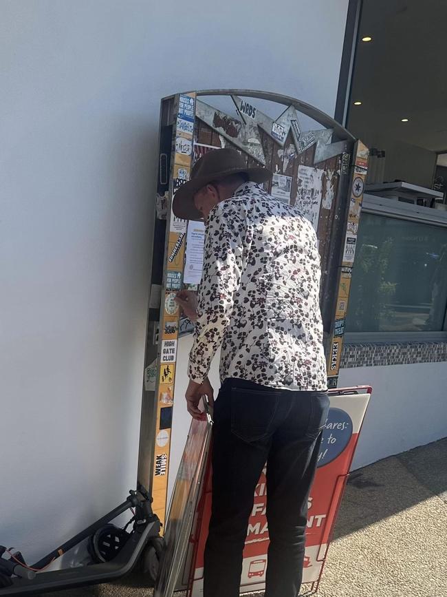 Mark Bailey caught trying to rip a Greens ‘build public housing’ sticker off a public notice board in Annerley on the weekend.