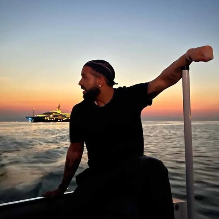 Canadian rapper Drake who chartered the megayacht last year shared a snap on the edge of a dingy with the massive floater in the background. Picture: Instagram/champagnepapi