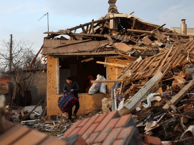 Local residents carry their belongings from a house destroyed by a Russian missile in Chuhuyiv, Kharkiv region. Picture: AFP