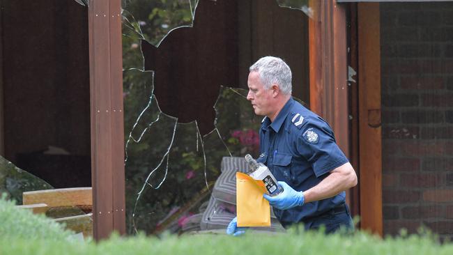 A police officer collects evidence at the scene. Picture: Jason Edwards