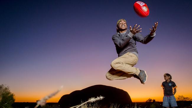 Joseph Coulthard takes a mark behind Uluru. Picture: JASON EDWARDS