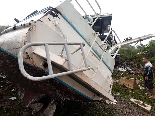 Bradley Mitchell inspects the damage to his uncle’s boat after it smashed against the bank at Shute Harbour, Airlie Beach, Wednesday, March 29, 2017. Picture: AAP Image/Dan Peled