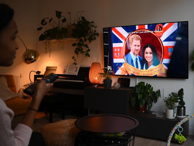 A woman watches an episode of the newly released Netflix docuseries Harry &amp; Meghan. Picture: AFP