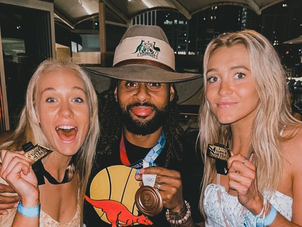 Patty Mills celebrates with Swifts stars Tayla Fraser and Helen Housby.