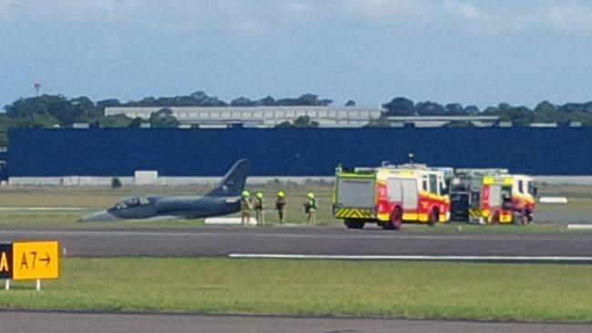 Firefighters near the jet which slid off the runway at Bankstown Airport.