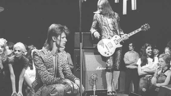 David Bowie performs 'The Jean Genie' on Top Of The Pops in 1973. Suzi Ronson stands to the right of frame dressed in a white T-shirt.