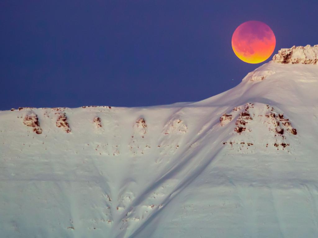 A super blue blood moon rises from behind a mountain near Longyearbyen, Svalbard, Norway. Picture: AFP