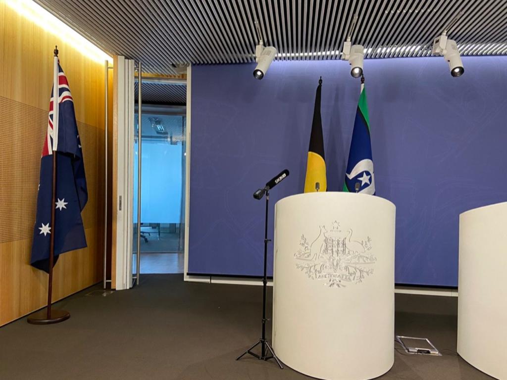 @Isobel Roe tweeted: Ahead of a press conference with Greens leader Adam Bandt, a Greens staffer has just moved the Australian flag out of the TV camera shot.