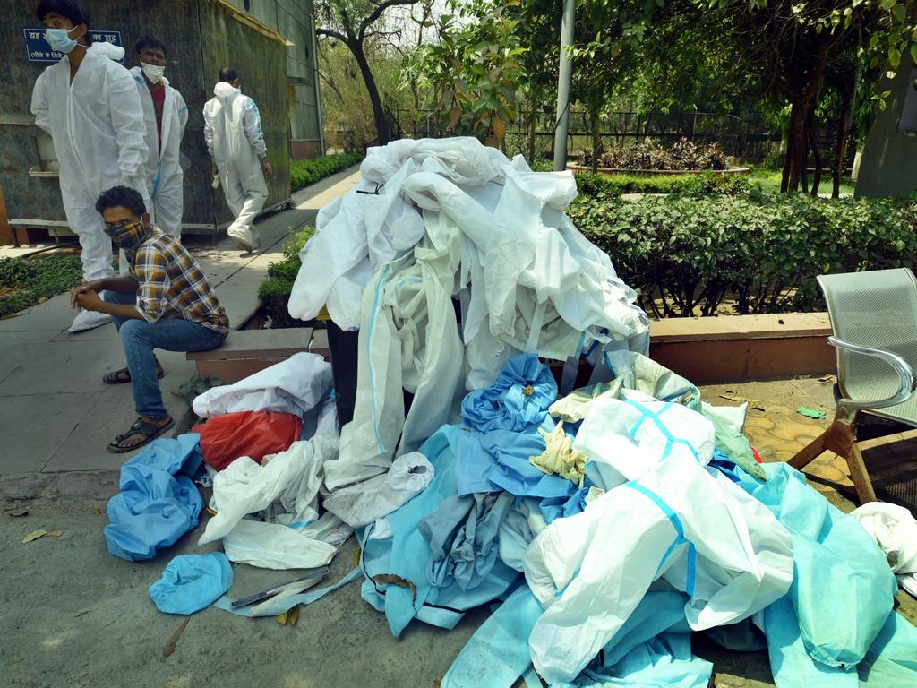 A pile of discarded PPE kits and other waste spills from a dustbin at Sector 94 crematorium on April 29 in Noida, India. Picture: Sunil Ghosh/Hindustan Times via Getty Images