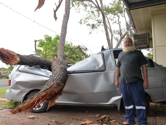 Fred Martin with his car, which was flattened by a fallen tree just as he was walking to move it during a storm in Moranbah, central Queensland.