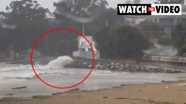 Water pours out of a main at Kingston Beach following intense rainfall