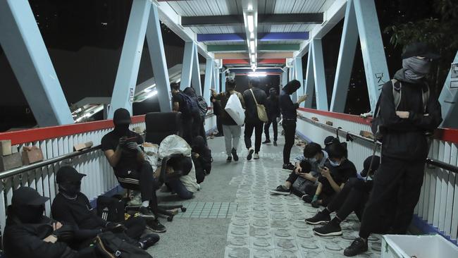 Protesters rest on a bridge in Hong Kong, early Saturday, Picture: AP