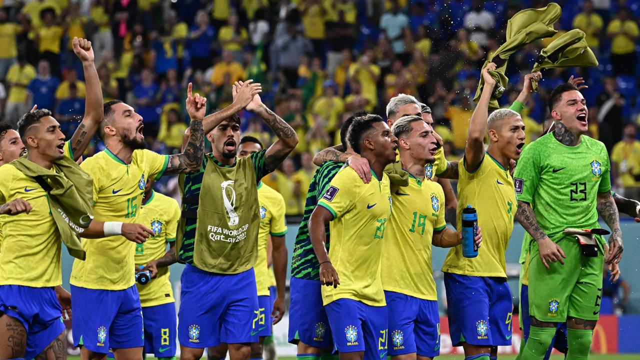 Brazil players celebrate with supporters after they won the Qatar 2022 World Cup Group G football match between Brazil and Switzerland at Stadium 974 in Doha on November 28, 2022. (Photo by Anne-Christine POUJOULAT / AFP)