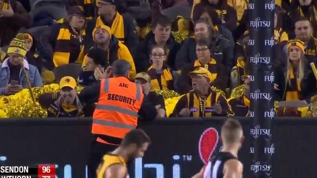 A security worker speaks to a Hawthorn cheer squad member.