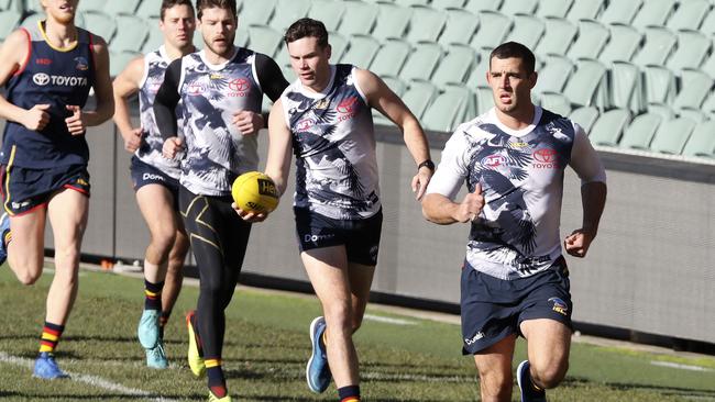 Crows captain Taylor Walker leads Mitch McGovern and Bryce Gibbs in a training run at Adelaide Oval this season. Picture SARAH REED