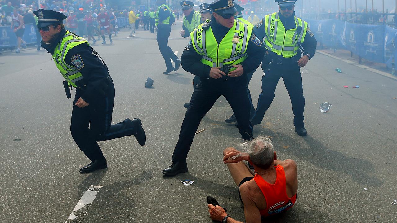 Police officers react to a second explosion at the finish line of the Boston Marathon on April 15, 2013 as a 78-year-old runner lies on the ground. Picture: AP Photo