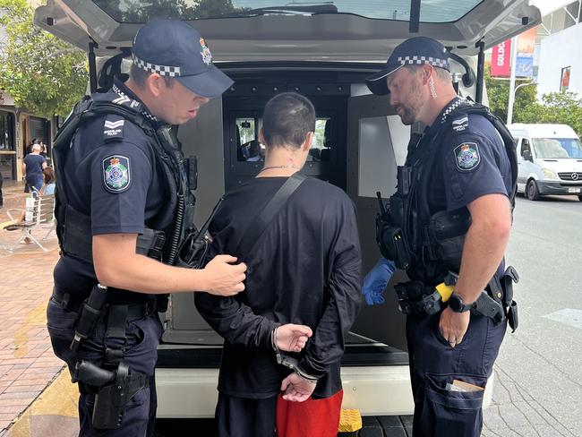 Police detain a person suspected of possessing drugs during wanding operations at Australia Fair in Southport. Picture: Keith Woods.