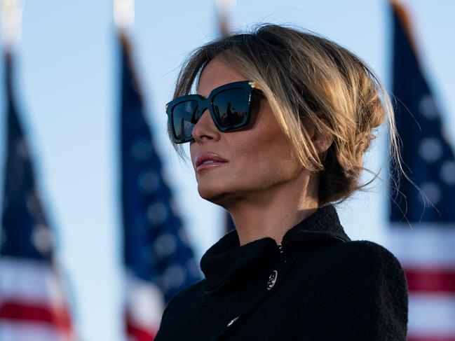 (FILES) In this file photo outgoing First Lady Melania Trump listens as her husband Outgoing US President Donald Trump addresses guests at Joint Base Andrews in Maryland on January 20, 2021. - The backdrop of flowers, teapot and US flag said it all: Jill Biden will be no Melania Trump as America's new first lady. Where Donald Trump's ex-model wife cut a flashy but often distant figure, Jill Biden's appearance on a Zoom "virtual tea" party February 3 with military spouses affirmed her image as a down-to-earth, traditional FLOTUS. (Photo by ALEX EDELMAN / AFP)