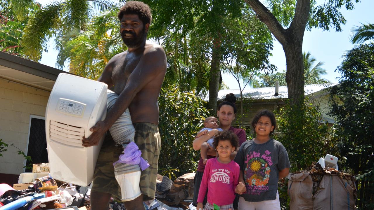 Michael Saveka and his partner Bonnie Short, with children Maria, Indie and baby Sam, were sorting through the destroyed contents of their Machans Beach home on Thursday. Picture: Bronwyn Farr