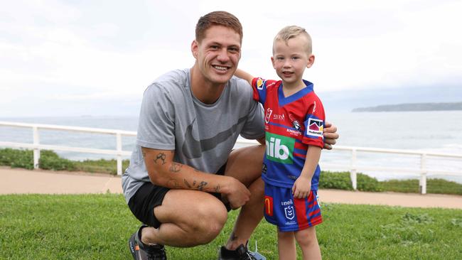 Kalyn Ponga with Kaleb Jones, 3, at the Donut King and Playstation launch event in Newcastle on Thursday. Picture: David Swift