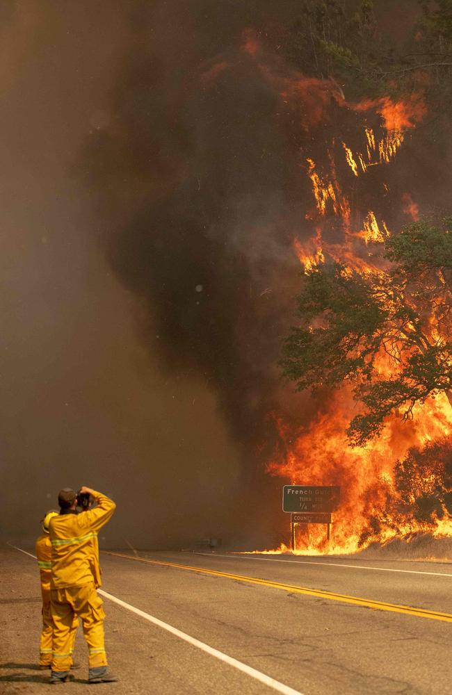 Photographers take photos as flames tower over a road during the Carr fire near Whiskeytown, California. Picture: AFP