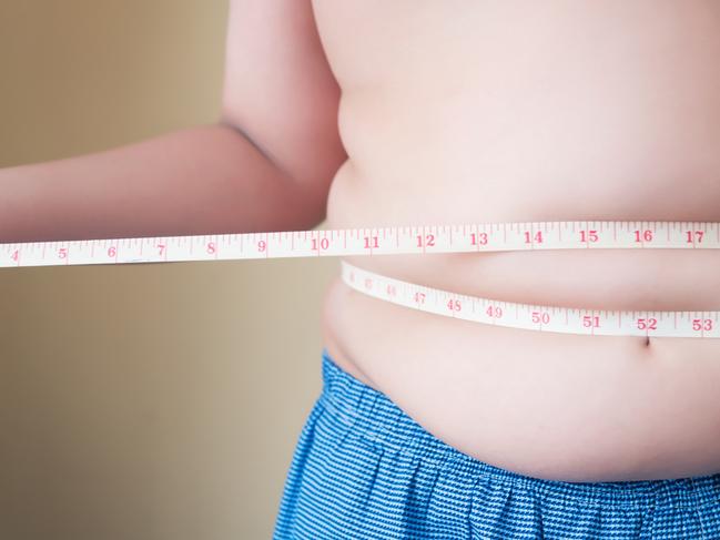 A generic stock image showing an obese or overweight child measuring his weight isolated on white background. Picture: istock