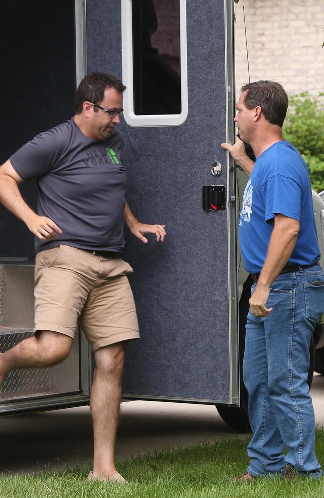 FILE – In this July 7, 2015 file photo Subway restaurant spokesman Jared Fogle leaves a mobile evidence-gathering lab outside of his home as Indianapolis Metropolitan Police Department Det. Darin Odier holds the door, in Zionsville, Ind. The extensive investigation that led this week to longtime Subway pitchman Jared Fogle agreeing to plead guilty to sex and child pornography crimes shines the brightest spotlight yet on an Indiana task force devoted to pursuing crimes against children that is one of the nation's most aggressive and effective child pornography hunters. (Charlie Nye/The Indianapolis Star via AP)