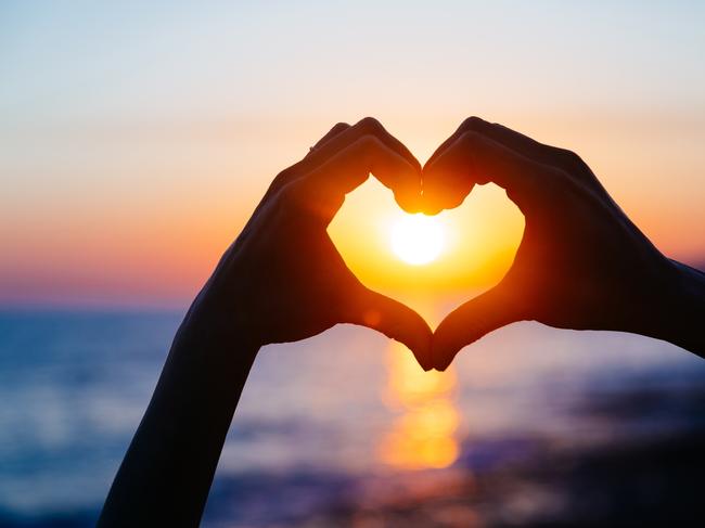 ESCAPE: Romance, Paul Ewart -  hands forming a heart shape with sunset silhouette. Copy space text. . Picture: iStock